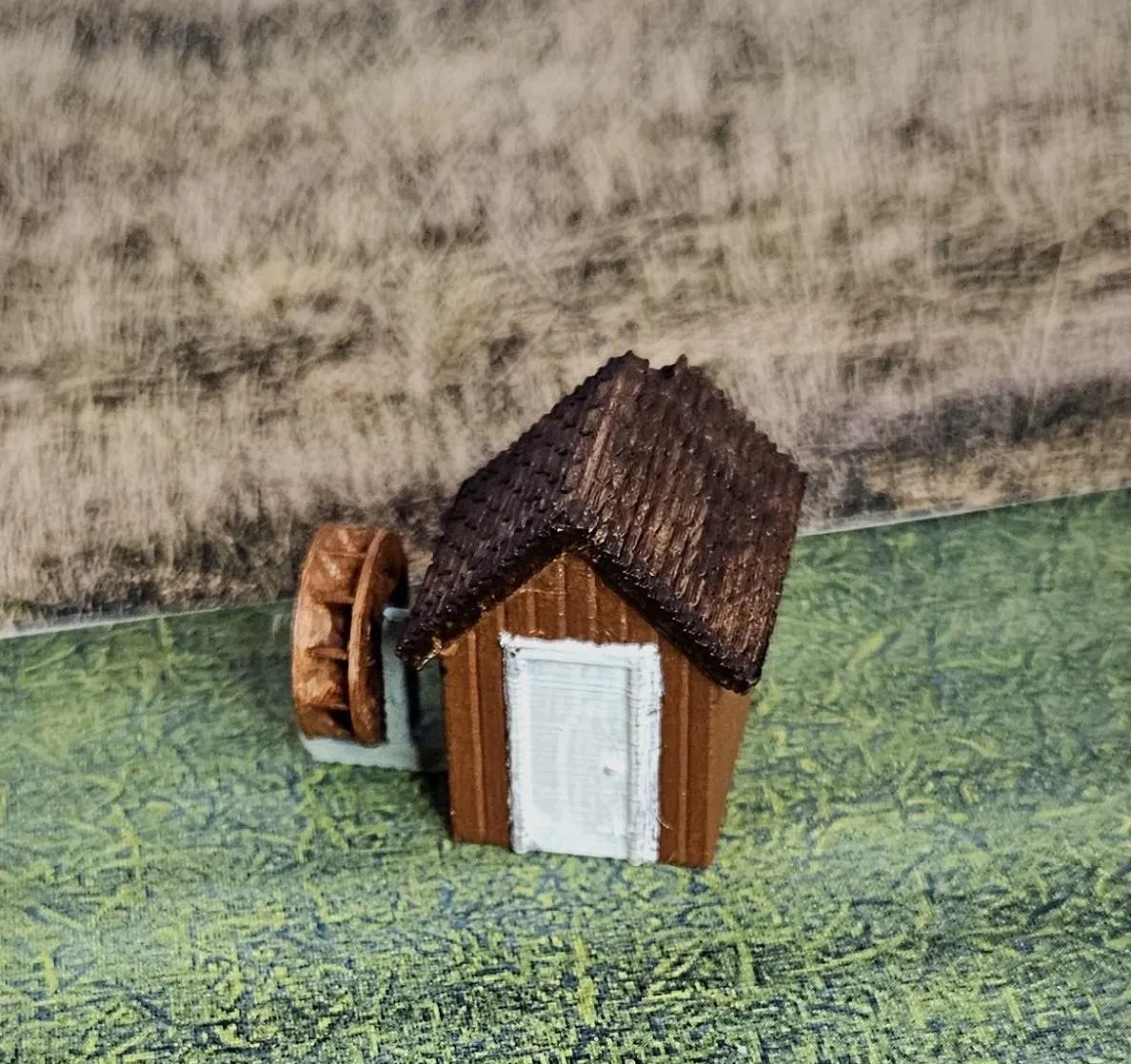 Rear angled view of N scale waterwheel with small building